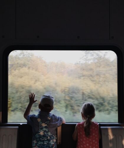 a-boy-and-a-girl-looking-outside-the-window-of-a-train