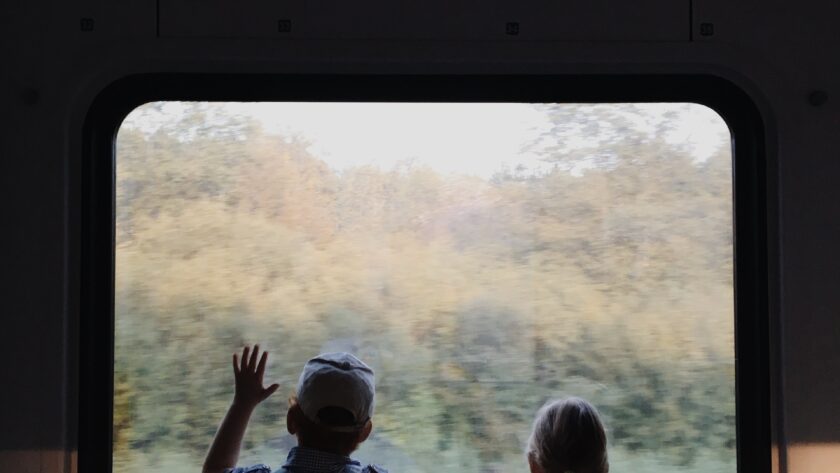 a-boy-and-a-girl-looking-outside-the-window-of-a-train