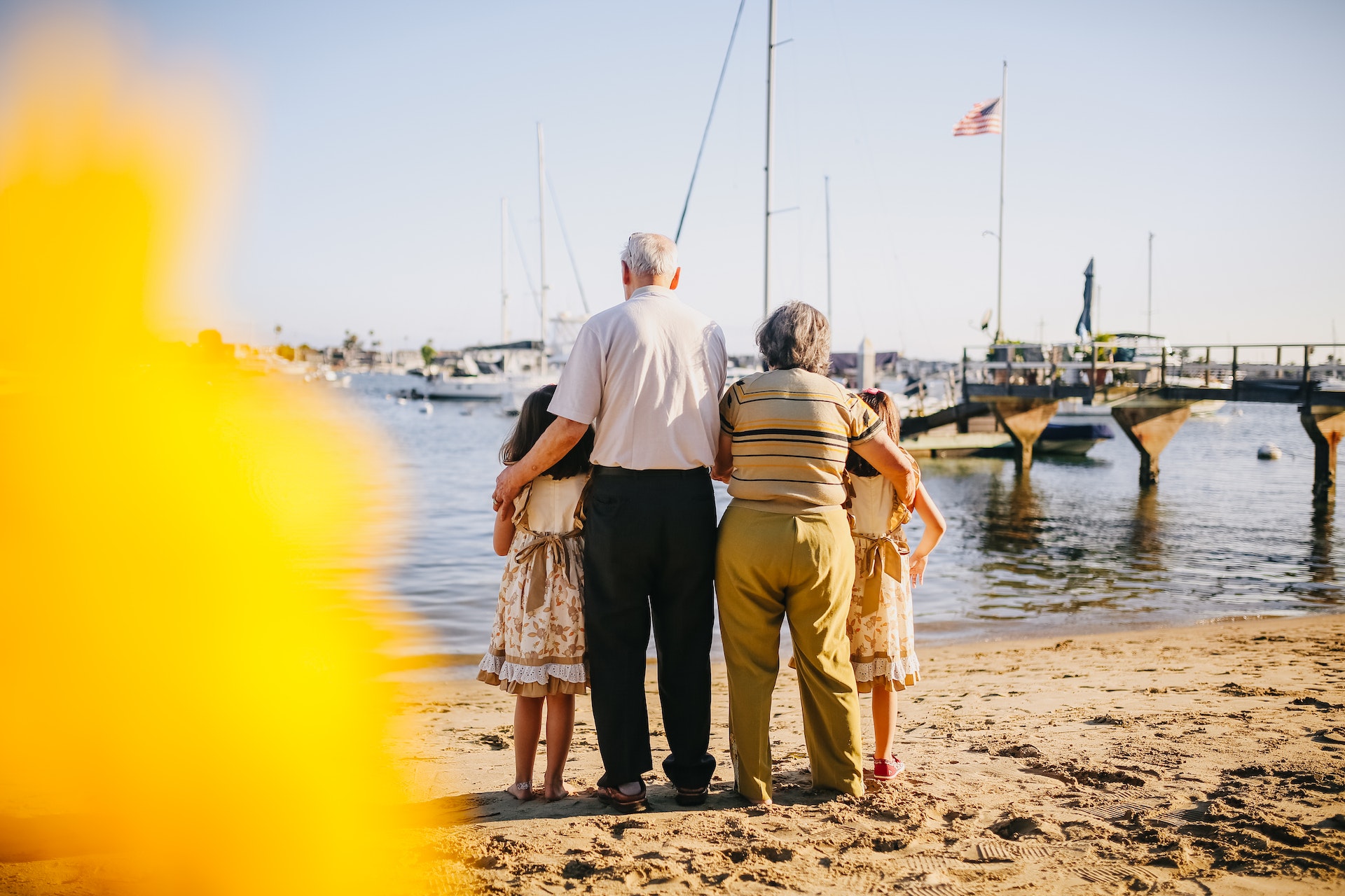 grandparents-with-their-granddaughters-standing-by-the-shore